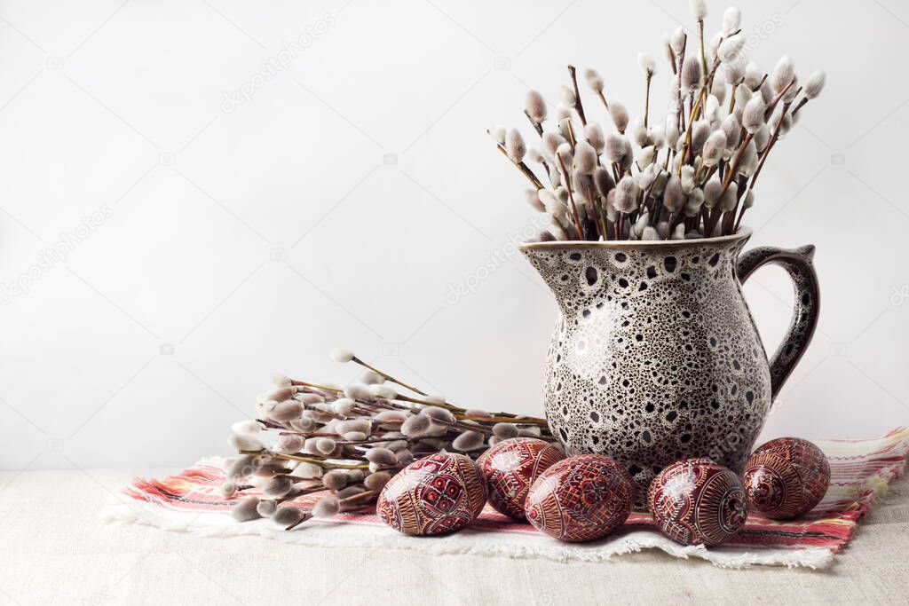 Still life with pysanka and willow branches in jug
