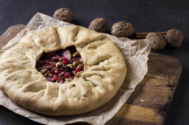 Elmalı, böğürtlenli ve fındıklı ev yapımı galette turtası. Kırsal arka planda taze inek çileğiyle süslenmiş.