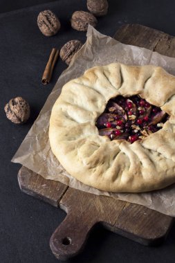 Elmalı, böğürtlenli ve fındıklı ev yapımı galette turtası. Kırsal arka planda taze inek çileğiyle süslenmiş.