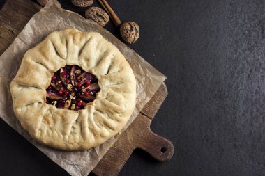 Elmalı ev yapımı galette turtası, yaşlı böğürtlen ve taşralı koyu arkaplanlı taze ahududu ile süslenmiş ceviz. Düz konum, üst görünüm, kopyalama alanı