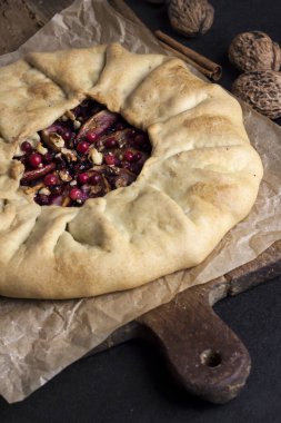 Elmalı, böğürtlenli ve fındıklı ev yapımı galette turtası. Kırsal arka planda taze inek çileğiyle süslenmiş.