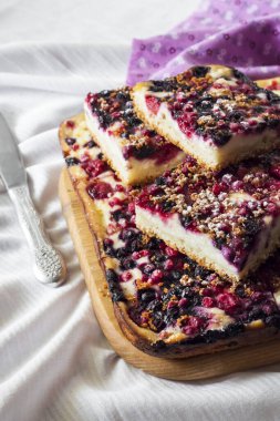 Çeşit çeşit böğürtlenli lezzetli turta ve ahşap bir tahtanın üzerinde kare şeklinde kesilmiş süzme peynir.