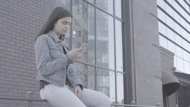 Attraente giovane donna utilizzando il suo telefono touch screen 4K — Video Stock