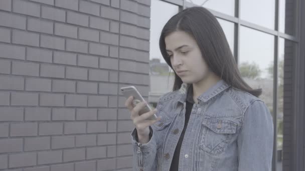 Jovem atraente usando seu telefone touch screen 4K — Vídeo de Stock