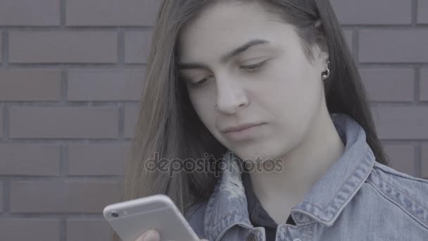 Mujer joven atractiva usando su teléfono de pantalla táctil 4K — Vídeo de stock