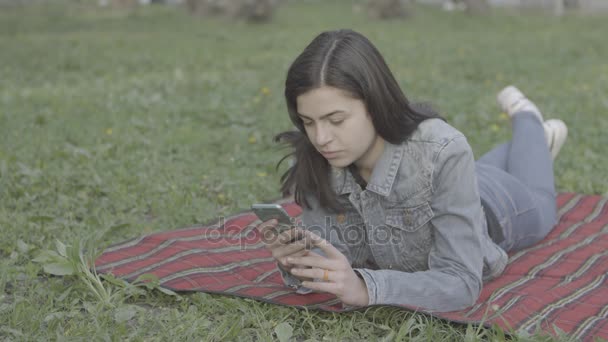 Mujer joven atractiva usando su teléfono de pantalla táctil 4K — Vídeos de Stock