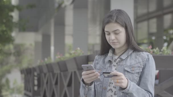 若い女性の 4 k のスマート フォンでのクレジット カードで支払い — ストック動画