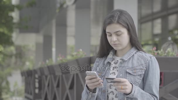 若い女性の 4 k のスマート フォンでのクレジット カードで支払い — ストック動画