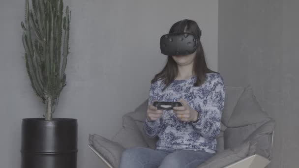 Junge Frau spielt Videospiele mit Virtual-Reality-Headset und Joystick — Stockvideo