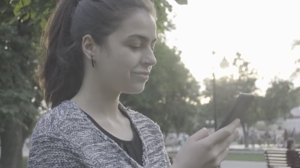 Mujer joven atractiva usando su teléfono de pantalla táctil 4K — Vídeo de stock