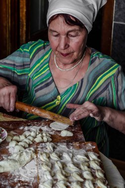 Büyükanne ravioli için mutfakta hamur rulo