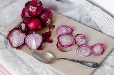 Bir ahşap tahta üzerinde kırmızı soğan dilimlenmiş