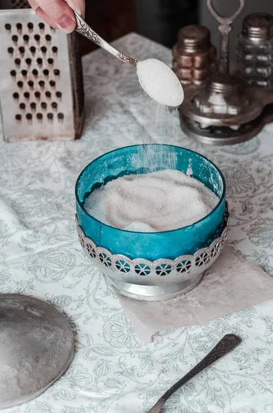 Baby hand pours sugar