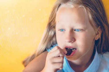 Kız vitaminler yiyor. Çilek