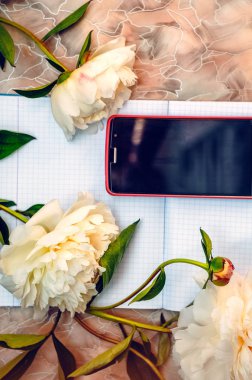 Beyaz sayfa üzerinde telefon. Masaüstü. Nazik peonies