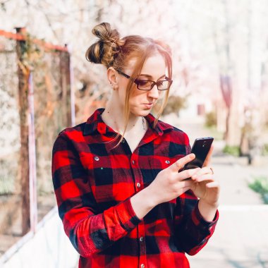 ciddi kız. telefonda bir şey dikkatle okur.