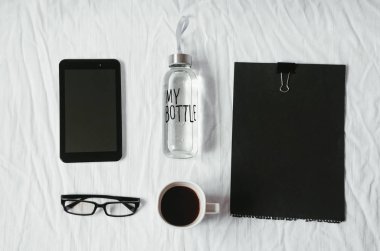 Masaüstü. temiz su şişe. gözlük ve teknoloji. sıcak güçlü kahve