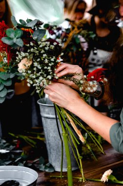 Çiçekçilikte mastır. Kız buket yapıyor..