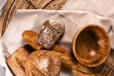 Çıtır çıtır, taze pişmiş ekmek. Tahta tabak. Tekstil. Hasır sepet. fırın