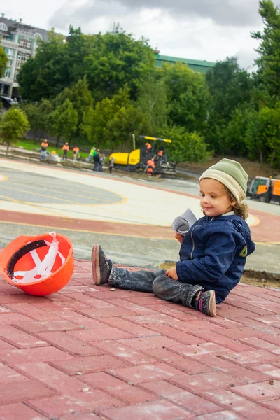 Construtor de menina pequena com o capacete de construção e cartaz — Fotografia de Stock