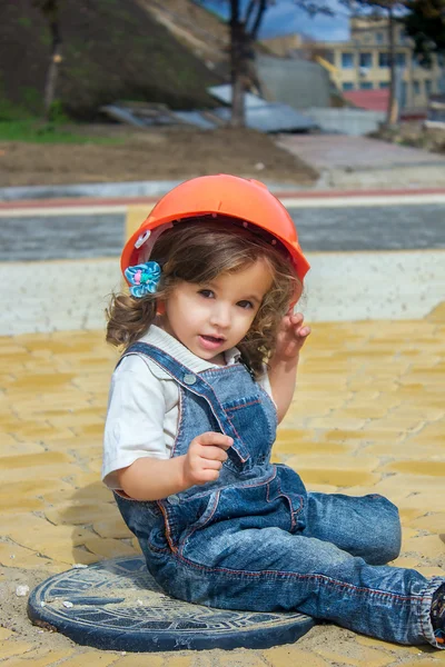 Construtor de menina pequena com o capacete de construção e cartaz — Fotografia de Stock