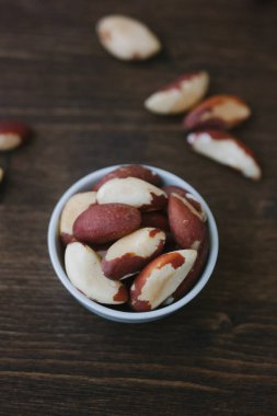 Brezilya fıstığı üzerinde beyaz seramik ahşap masa üzerinde kase