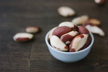 Brezilya fıstığı üzerinde beyaz seramik ahşap masa üzerinde kase