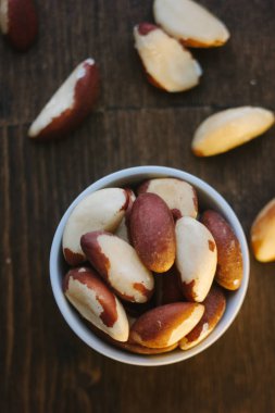 Brezilya fıstığı üzerinde beyaz seramik ahşap masa üzerinde kase