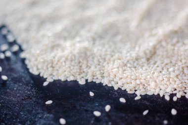 Siyah metal tepsi üzerinde beyaz susam.