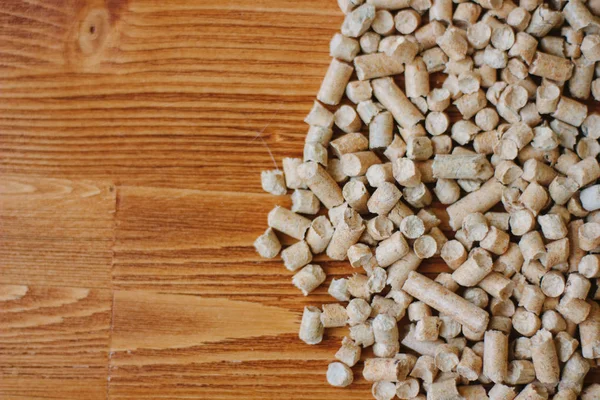 Biobrandstof - kleine houten pellets over de houten tafel. — Stockfoto