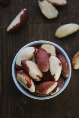 Brezilya fıstığı üzerinde beyaz seramik ahşap masa üzerinde kase