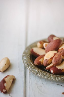 Brezilya fıstığı Beyaz ahşap masa üzerinde metal plaka.