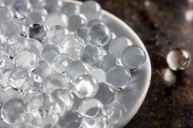 Siyah metal zemin üzerinde beyaz plaka üzerinde hidrojel topları