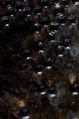 Siyah metal zemin üzerinde hidrojel topları.