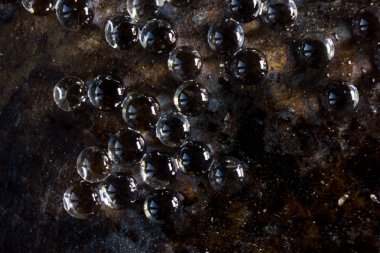 Siyah metal zemin üzerinde hidrojel topları.