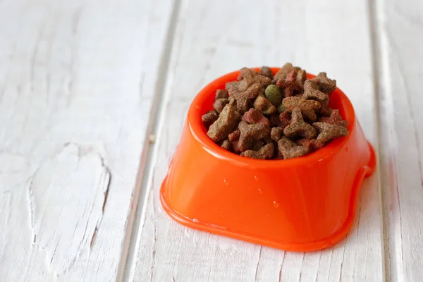 Comida para mascotas en un tazón para gatos. Pienso seco en tazón de naranja . — Foto de Stock