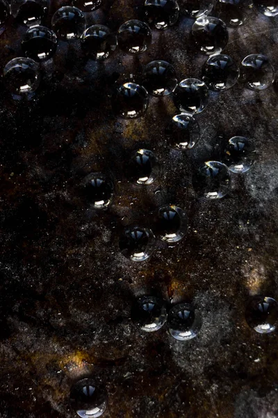 Siyah metal zemin üzerinde hidrojel topları.