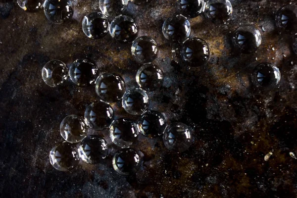 Siyah metal zemin üzerinde hidrojel topları.