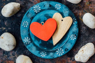 Rustik arka plan üzerinde mavi plaka üzerinde iki kalp