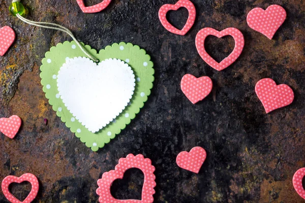 Vista superior del corazón verde con los corazones rosados sobre fondo negro . — Foto de Stock