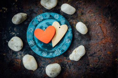 Rustik arka plan üzerinde mavi plaka üzerinde iki kalp