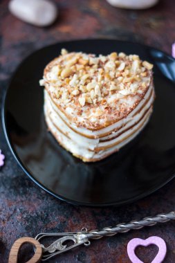 Güzel kalp kek siyah plaka üzerinde yemeye hazır.