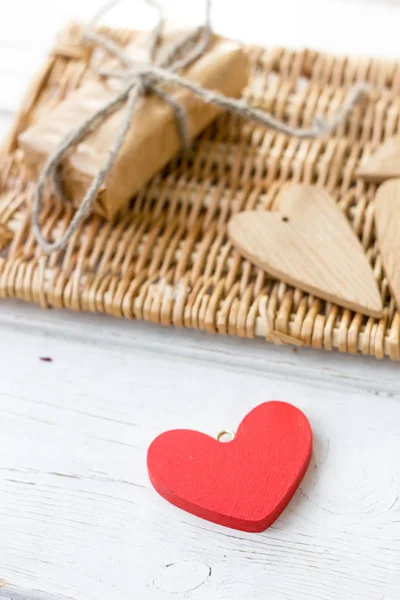 Un rojo y unos pocos corazones de madera marrón - regalo para el día de San Valentín — Foto de Stock
