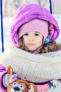Küçük kız kış park kızağa oturan