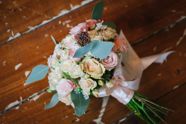 Beutiful wedding bouquet over brown wooden floor. — Stock Photo, Image