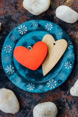 Rustik arka plan üzerinde mavi plaka üzerinde iki kalp