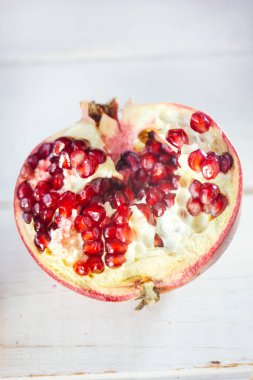 Beyaz ahşap yüzeyde taze nar parçaları..