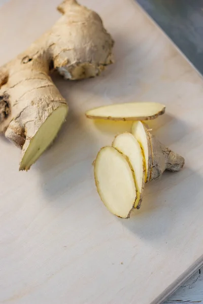 Slices of ginger root on wooden board.
