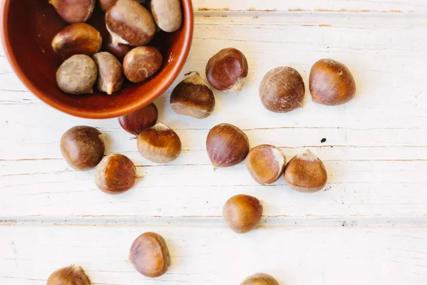 Castanhas castanhas sobre a superfície de madeira . — Fotografia de Stock