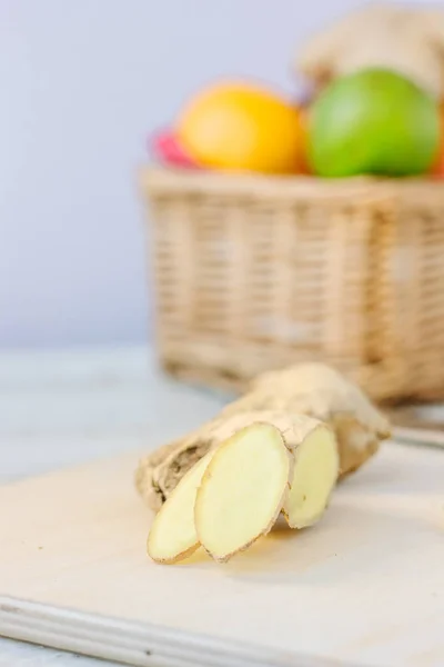 Rodajas de jengibre sobre mesa de madera con frutas frescas . —  Fotos de Stock